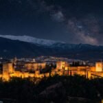 Alhambra Palace illuminated at night with Sierra Nevada mountains in background, Granada Spain
