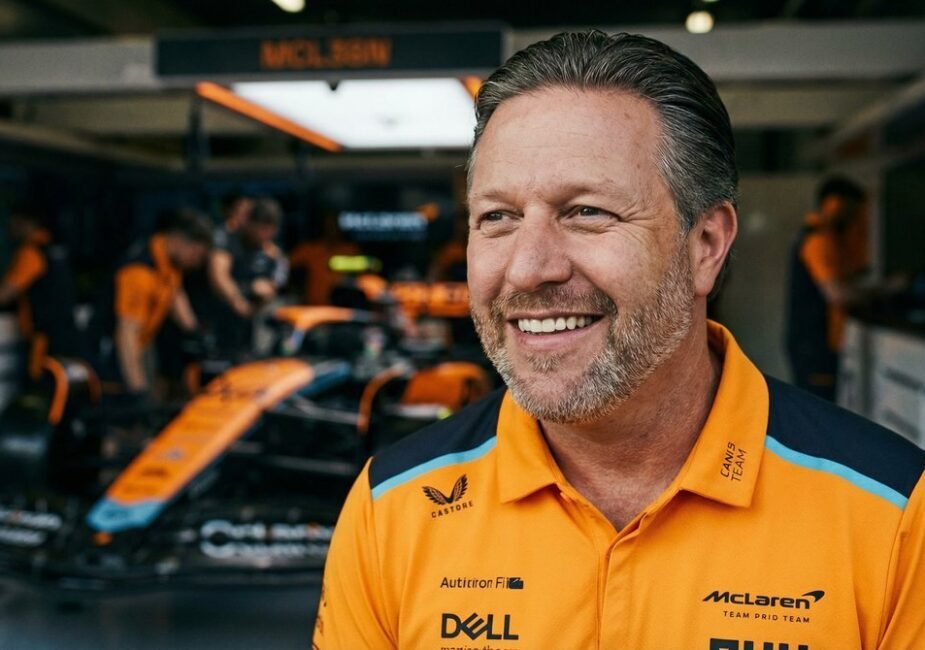 Zak Brown, CEO of McLaren Racing, standing in front of a McLaren Formula 1 car in the team garage